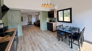 Cozinha ampla com área de refeições, piso de madeira e vista pela janela.