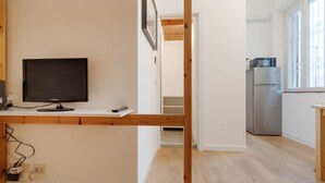 A modern apartment with a wooden floor, a flat-screen TV, a kitchen with a refrigerator, and a window. - GuestHost - Comfortable and practical 22 square meters studio apartment, perfect for two people, located on the second floor of a building without an elevator.The property is located in the Corvetto neighborhood, a lively area characterized by green spac (Milan)
