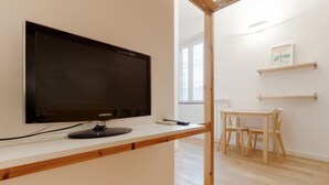 A modern room with a flat-screen TV, a wooden table, and chairs. - GuestHost - Comfortable and practical 22 square meters studio apartment, perfect for two people, located on the second floor of a building without an elevator.The property is located in the Corvetto neighborhood, a lively area characterized by green spac (Milan)