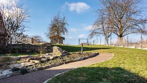 A park with a gravel path, stone structures, and leafless trees. - Apartment “Zum Weißen Roß” with Shared Garden and Wi-Fi (Hausen)