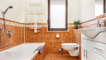 A bathroom with a bathtub, toilet, and sink.