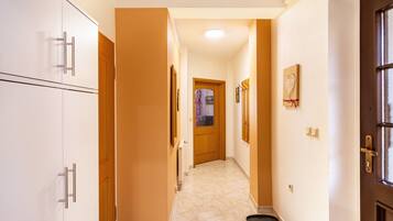 A hallway with a wooden door, a radiator, and a picture frame on the wall.