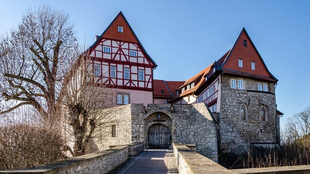 A historic building with a stone entrance, red and white timber framing, and a steeply pitched roof. - Apartment “Zum Weißen Roß” with Shared Garden and Wi-Fi (Hausen)