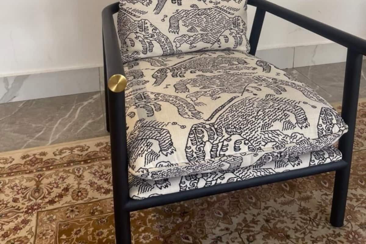 A chair with a patterned cushion and a round wall decoration.