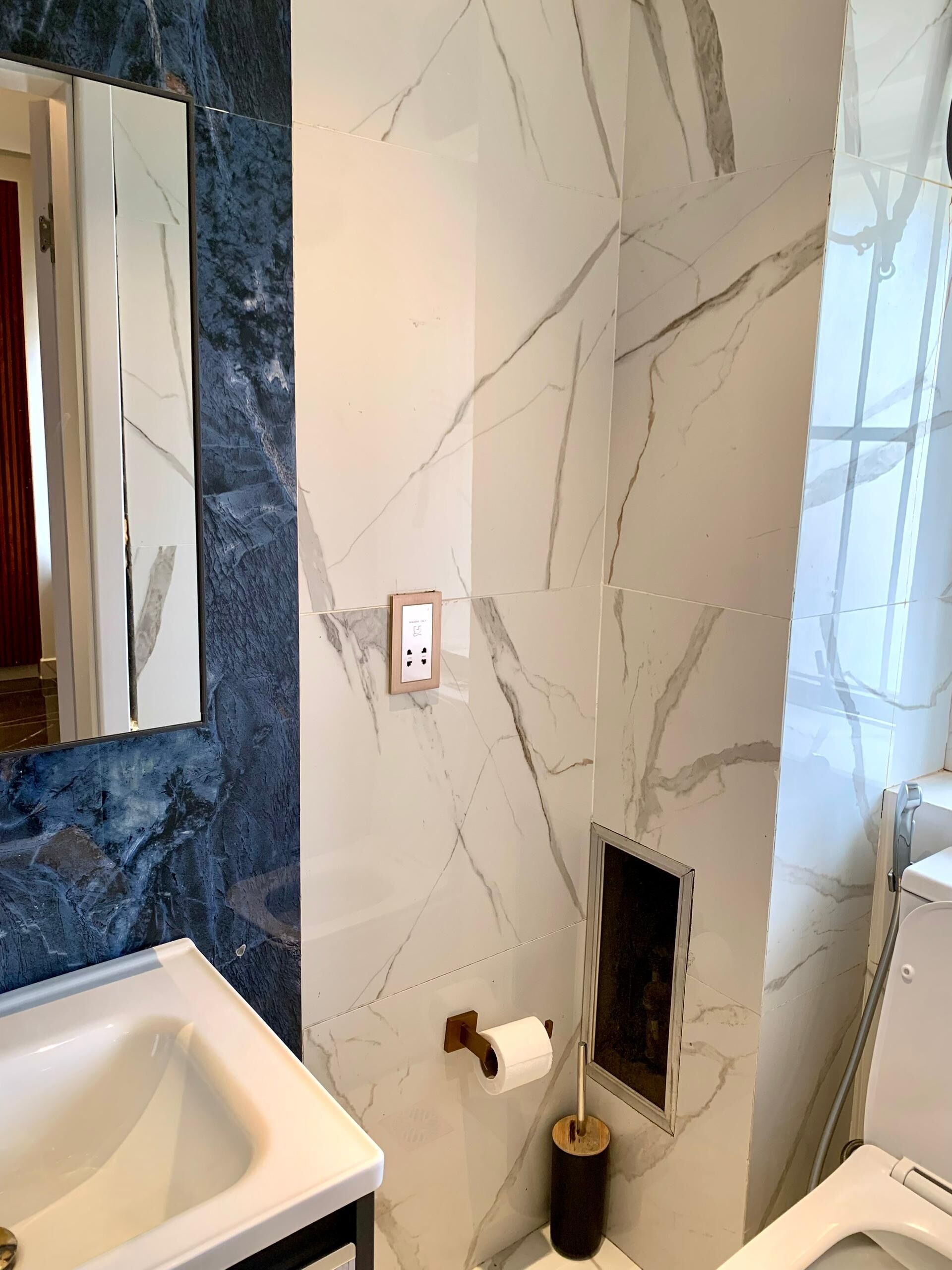 Un baño con lavabo blanco, espejo, inodoro y ducha.