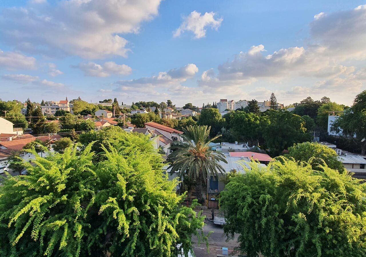 A residential area with houses, trees, and a clear sky.