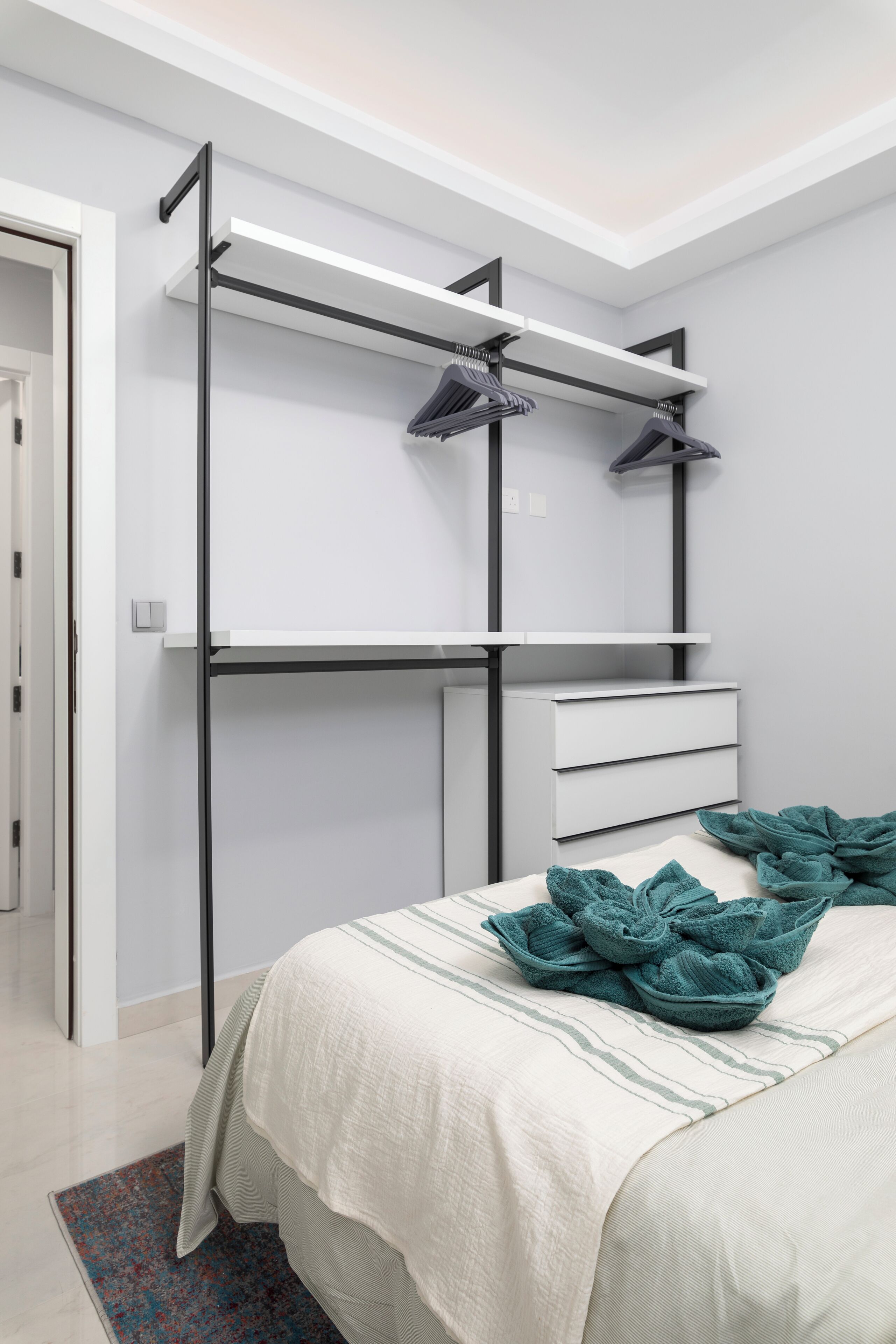 A bedroom with a bed, a built-in wardrobe, and a ceiling fan.