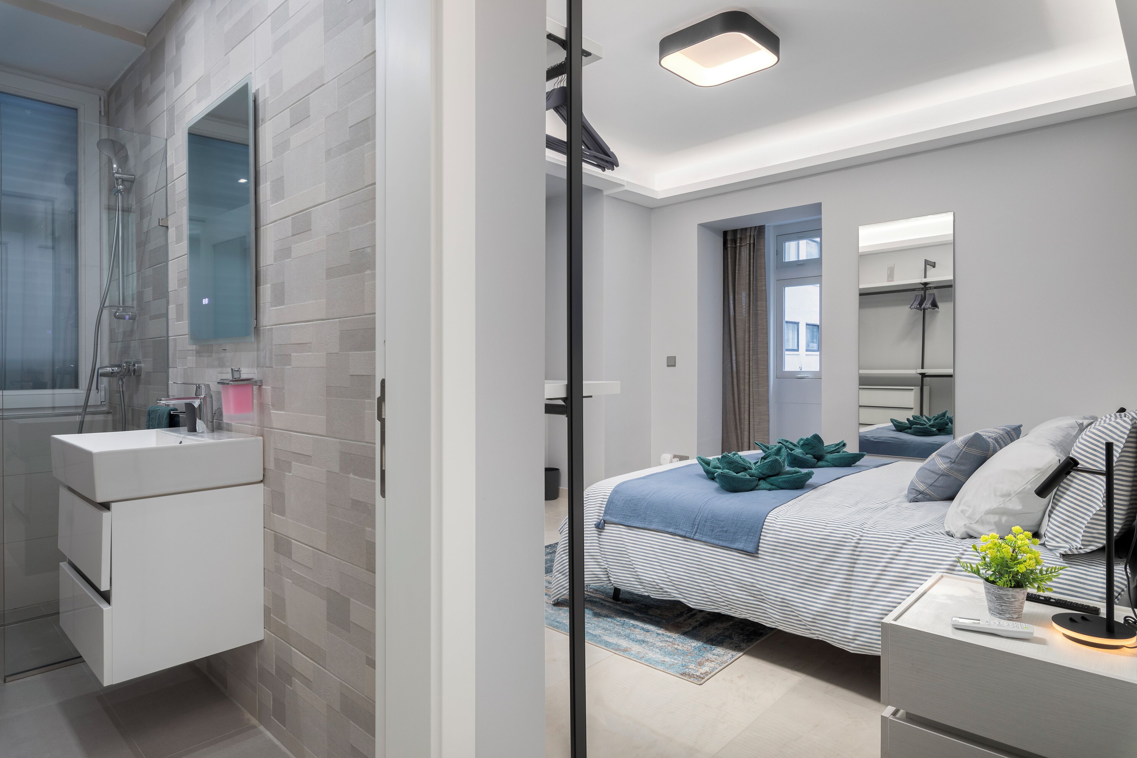 Ein modernes Schlafzimmer mit Bett, Nachttisch und Beistelltisch.