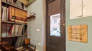 Une pièce avec une porte sombre, une fenêtre et un panneau fixé au mur sur lequel on peut lire : « Le chocolat, c’est toujours une bonne idée. »