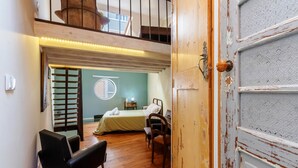 Une pièce avec une mezzanine, un lit, un bureau et une chaise.