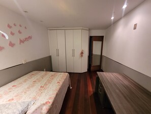 A bedroom with a bed, a wardrobe, and a desk. - Carnival in Rio, 30 minutes from Copacabana, right in front of the beach. (Rio de Janeiro)