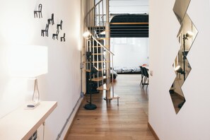 Ein modernes Interieur mit Treppe, Schreibtisch mit Lampe und einem Spiegel mit ungewöhnlicher Form.