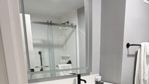 A modern bathroom with a white sink, black faucet, and a mirror above it. There is a towel rack on the wall and a wooden shelf under the sink. - Hotel Kiva, An Ascend Collection Hotel (Albuquerque)
