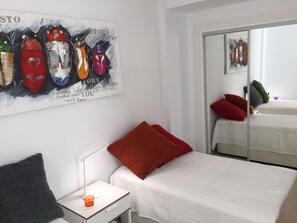 A hotel room with a bed, a nightstand, a lamp, and a painting on the wall. - Seaside 2 Bedroom Condo Fuengirola Spain (Fuengirola)