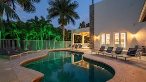 A pool area with lounge chairs and a building with a stone facade. - 8k+ SF Mansion Cinema/Pool/Game Room (Plantation)