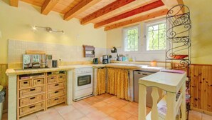 A compact kitchen with wooden cabinets, a stove, and a sink. - Cézanne - Comfort, space and relaxation for families and friends, park view (ARLES)