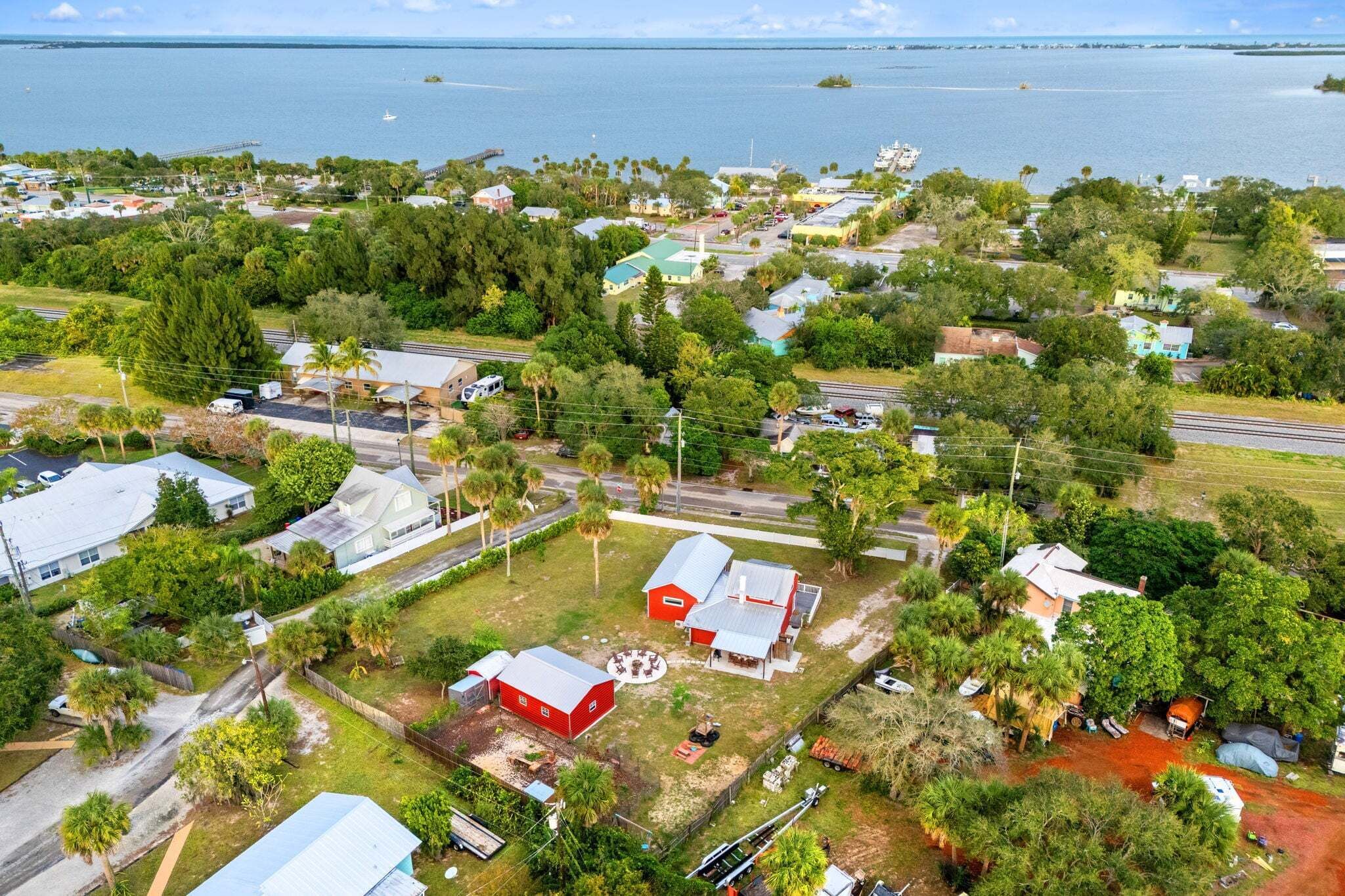 Vista aérea de una zona residencial con casas, carreteras y una masa de agua al fondo.