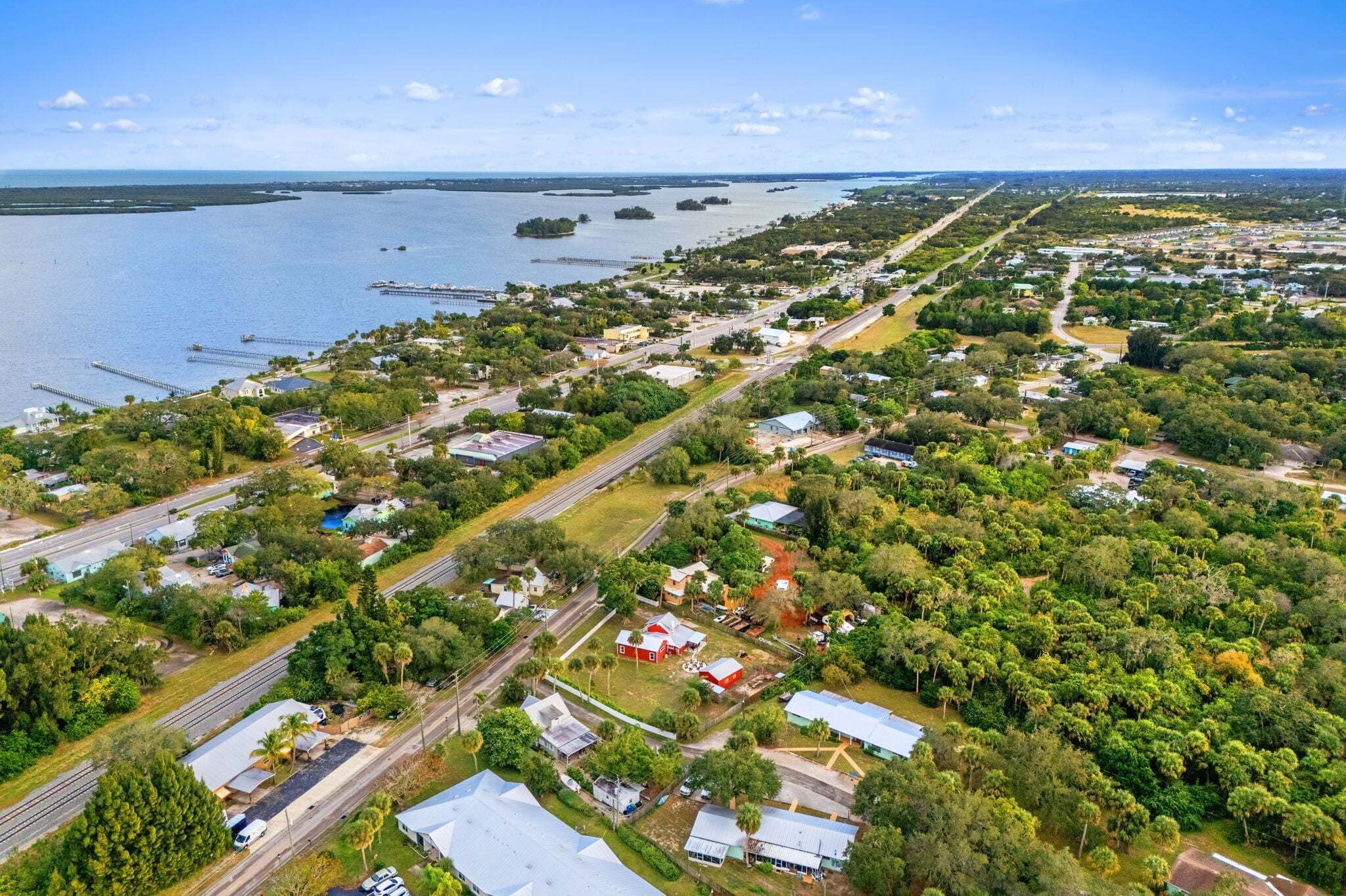 An aerial view of a coastal town with residential areas, roads, and a marina.