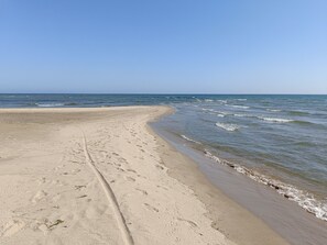 Una platja sorrenca amb empremtes i una vista clara de l'oceà.