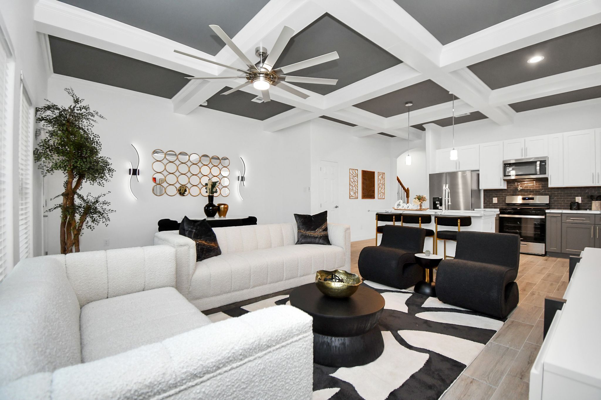 Un salon moderne avec un canapé, une table basse et un coin repas avec des chaises.
