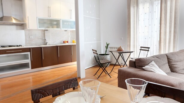 Een modern appartement met keuken, eethoek en woonkamer.