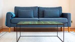 Ein blaues Sofa mit einem gemusterten Tisch davor.