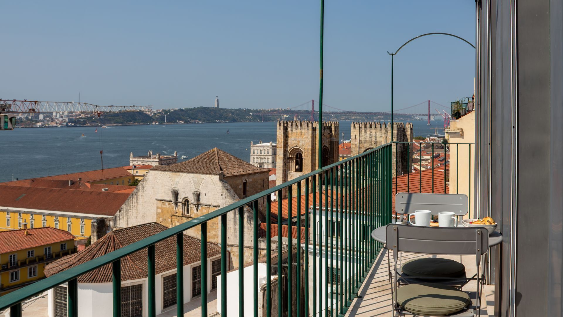 A balcony with a view of a river, a bridge, and historic buildings.