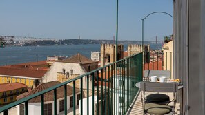 Ein Balkon mit Blick auf einen Fluss, eine Brücke und historische Gebäude.
