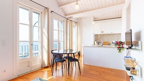 A modern kitchen with white cabinets, a wooden countertop, and a built-in oven. - Alfama Terrace River View by LovelyStay (Lisboa)