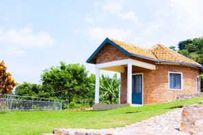 A single-story brick house with a tiled roof, a covered porch, and a blue door.