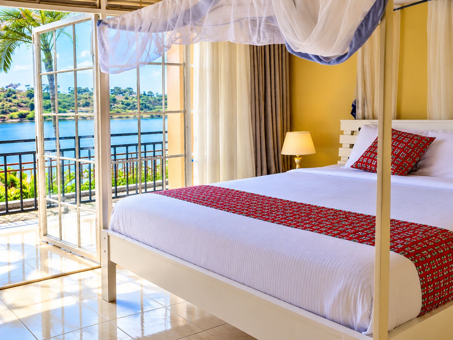 Una cama con dosel, vistas a un lago y un balcón con barandilla.