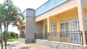 Un bâtiment doté d’une façade en pierre, d’un balcon avec une rambarde en métal et d’un trottoir pavé.