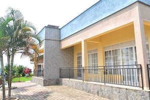 A building with a stone facade, a balcony with a metal railing, and a paved walkway. - Mariebu Beach Apartment  (Boneza)