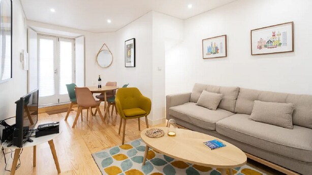 Una sala de estar moderna con un sofá, una mesa de centro y un comedor con sillas y una mesa.