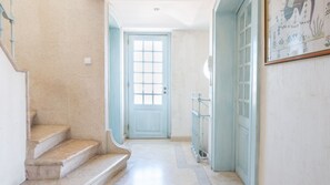 A hallway with a marble staircase leading to a door with a grid pattern. - Penthouse Terrace 360º Lisbon View by LovelyStay (Lisboa)