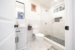 A modern bathroom with a toilet, sink, and shower.