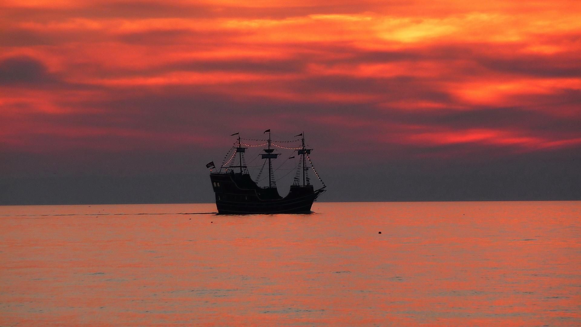 A ship at sea during sunset.