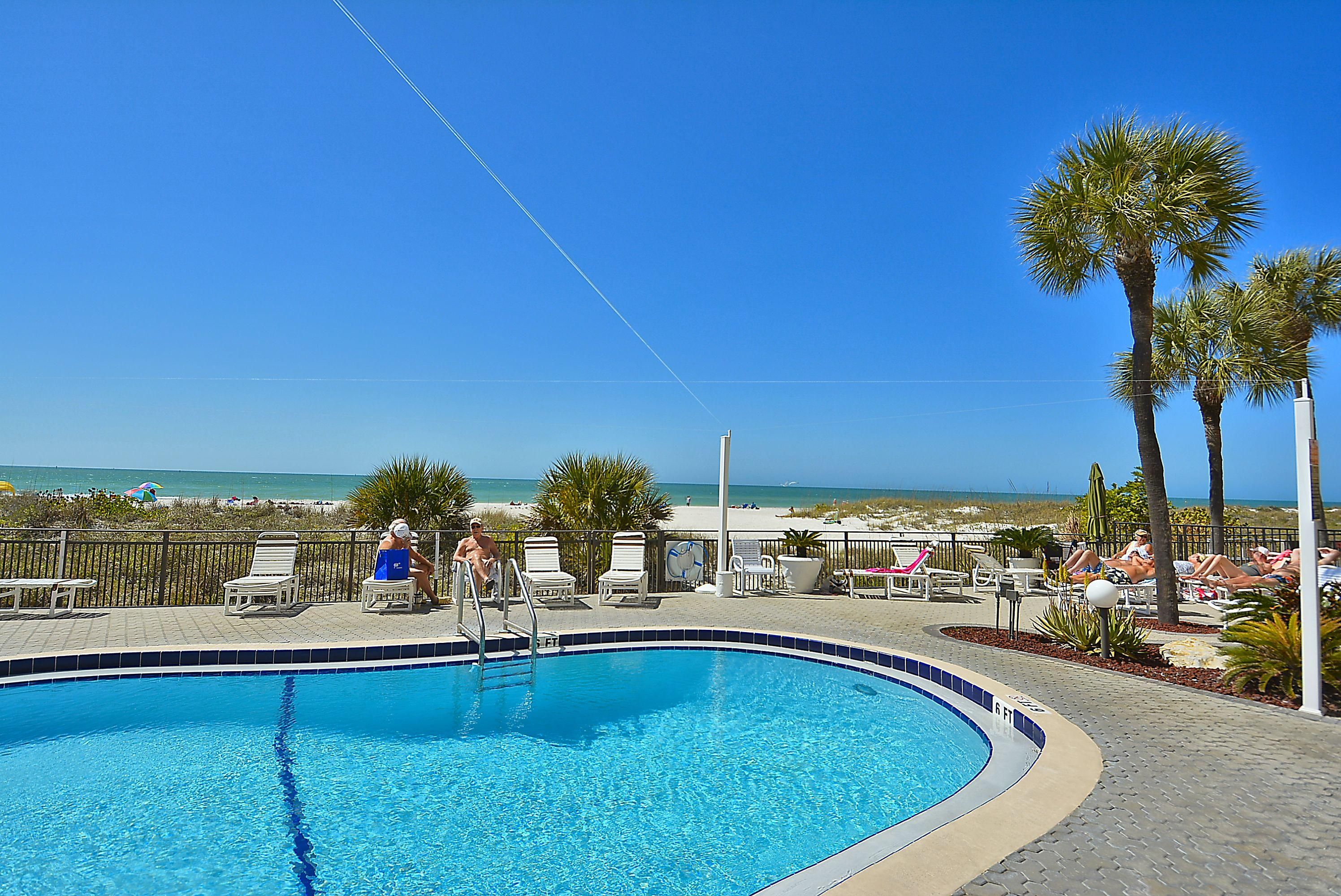 A swimming pool with a view of the beach and ocean.