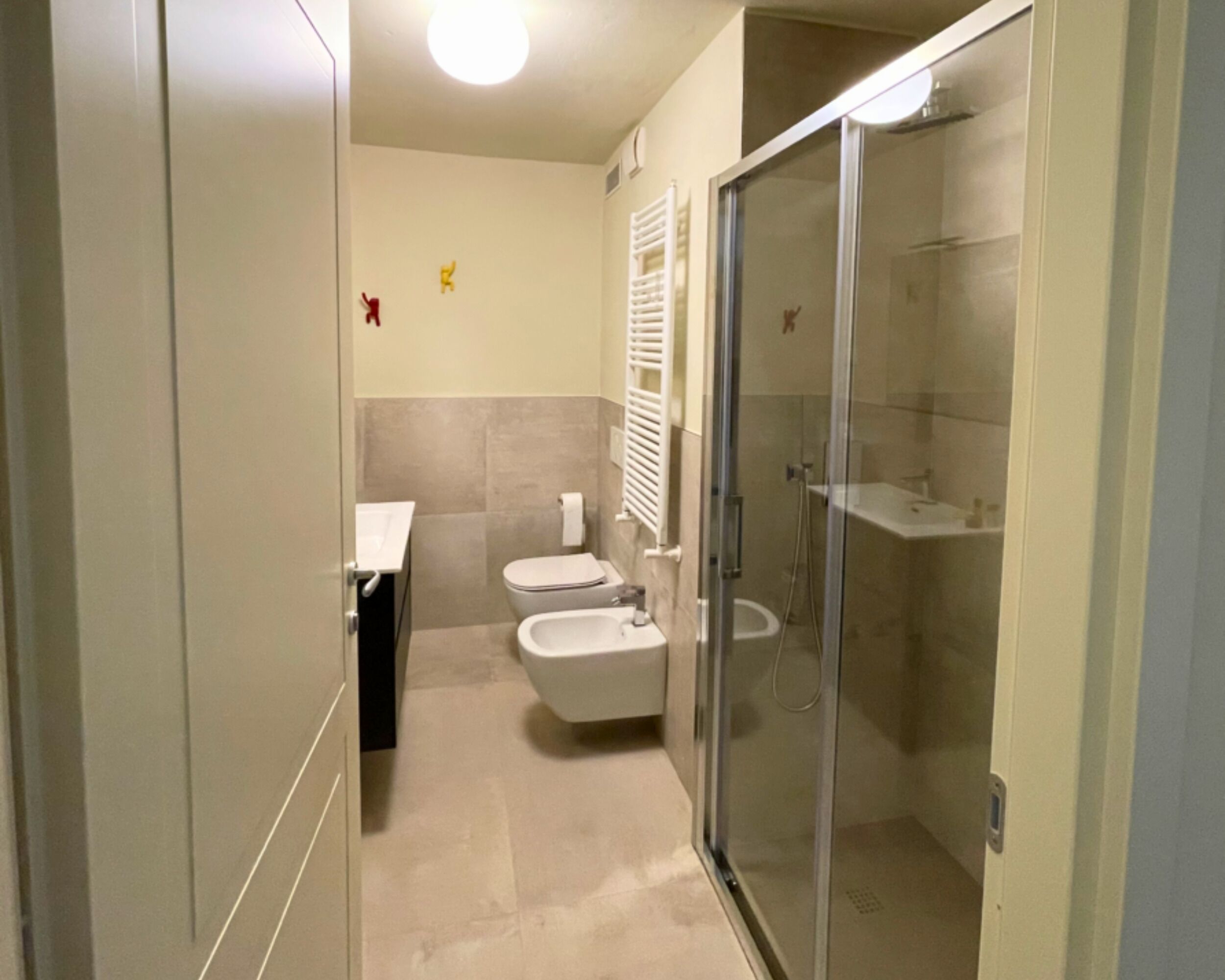 A modern bathroom with a toilet, bidet, and a glass-enclosed shower.