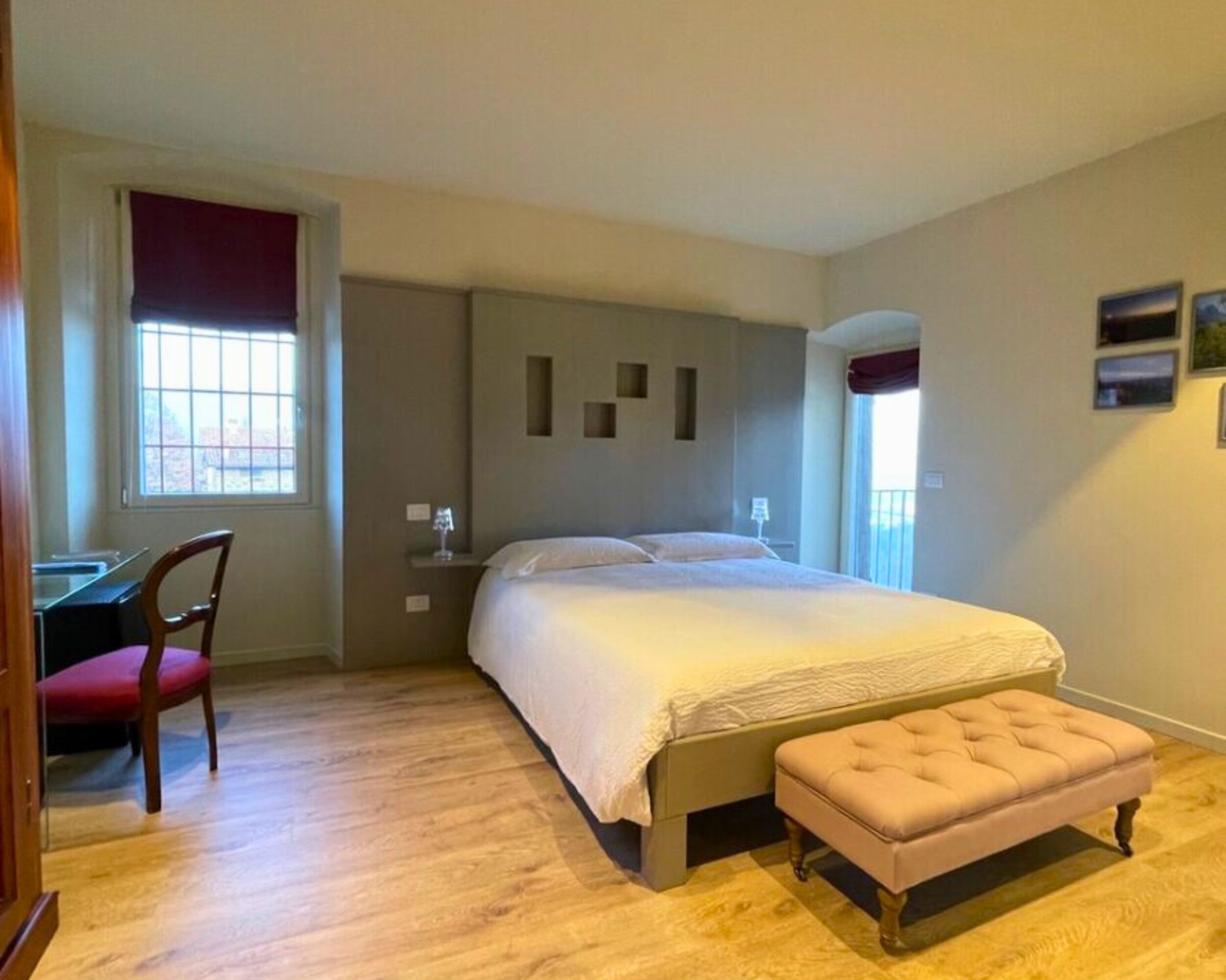 A bedroom with a bed, a desk, a chair, and a window.