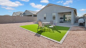 A modern house with a patio area featuring a small lawn and outdoor furniture. - Cozy Phoenix Home 4 Bedrooms Family friendly & Fast Wi-Fi (Phoenix)