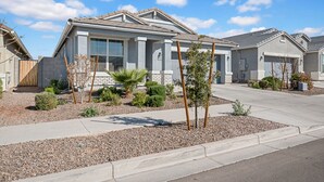 A residential house with a grey facade, a front porch, and a landscaped garden with small trees and shrubs. - Cozy Phoenix Home 4 Bedrooms Family friendly & Fast Wi-Fi (Phoenix)