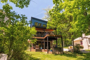 A two-story building with a balcony, surrounded by greenery. - Bear on the Lake (Oakland)
