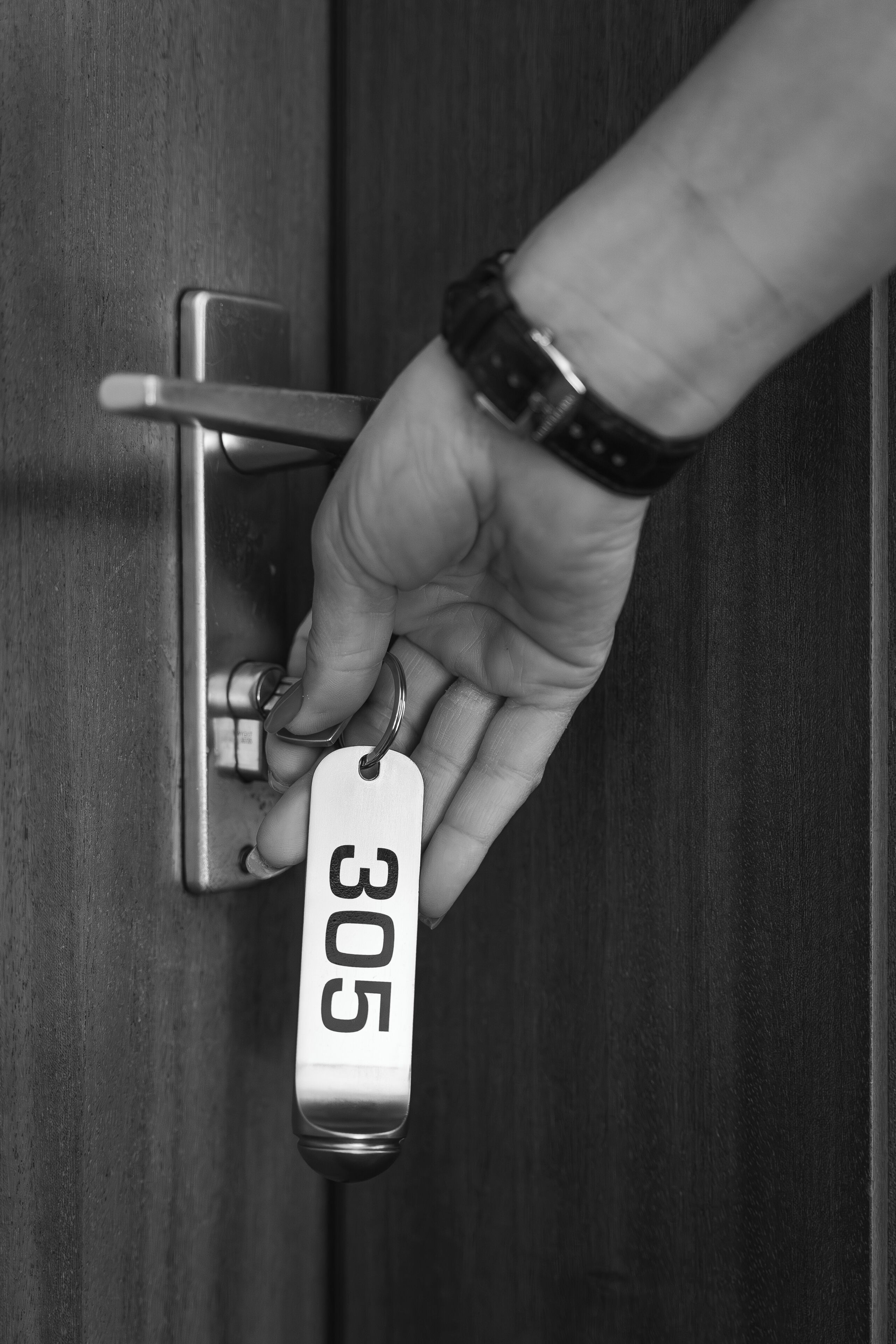 Une main insérant une clé dans une serrure de porte.