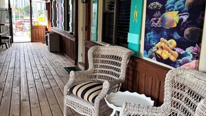 A wooden deck with wicker chairs and a mural of fish. - 110 Signature Single Room in waterfront hotel in Singer Island, FL (Riviera Beach)