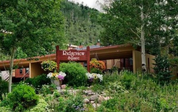 A lodge named Ridgeview Square surrounded by lush greenery and a mountainous backdrop.