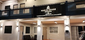 Ein mehrgeschossiges Gebäude mit einem Schild, auf dem 'MARIN HOUSE PATTAYA' und Kontaktdaten stehen.