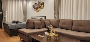 Ein modernes Wohnzimmer mit Sofa, Bett und Couchtisch mit Dekorationselementen.