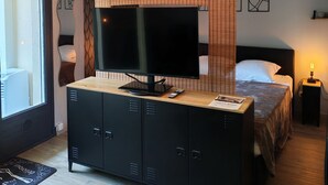 A bedroom with a bed, a TV on a wooden cabinet, a ceiling fan, and a window. - LARGE STUDIO - CLOSED LOGGIA - SHOWER - AIR CONDITIONING - BED 160 - RENOVATED (AMELIE LES BAINS)
