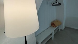 Huoneessa on valkoinen lamppu, penkki ja penkillä pyyhe.